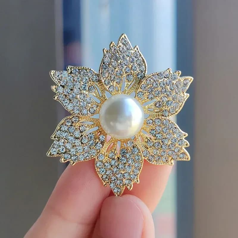 faux pearl flower brooch held in the hand