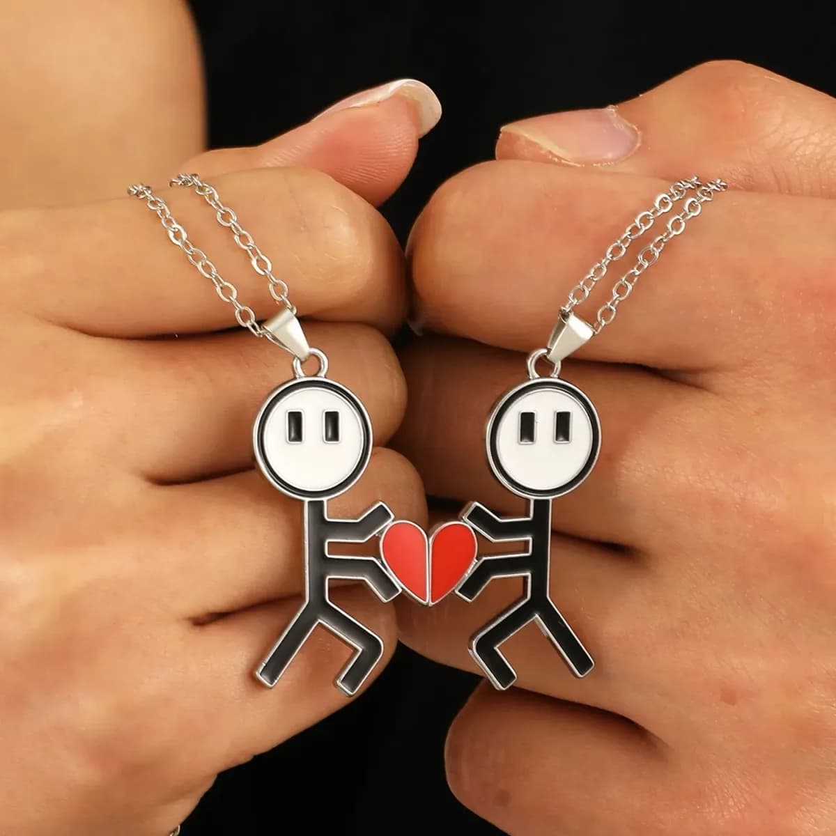 matching couple necklaces with magnetic heart halves joined between two hands